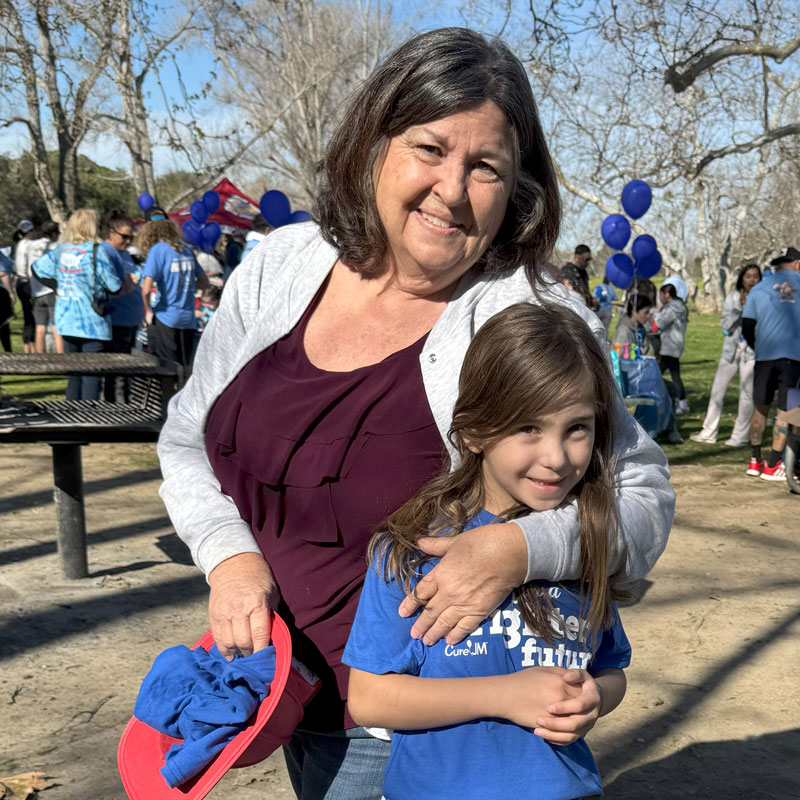 Lynn Neuenswander and child at Southern California Chapter Walk Strong to Cure JM event