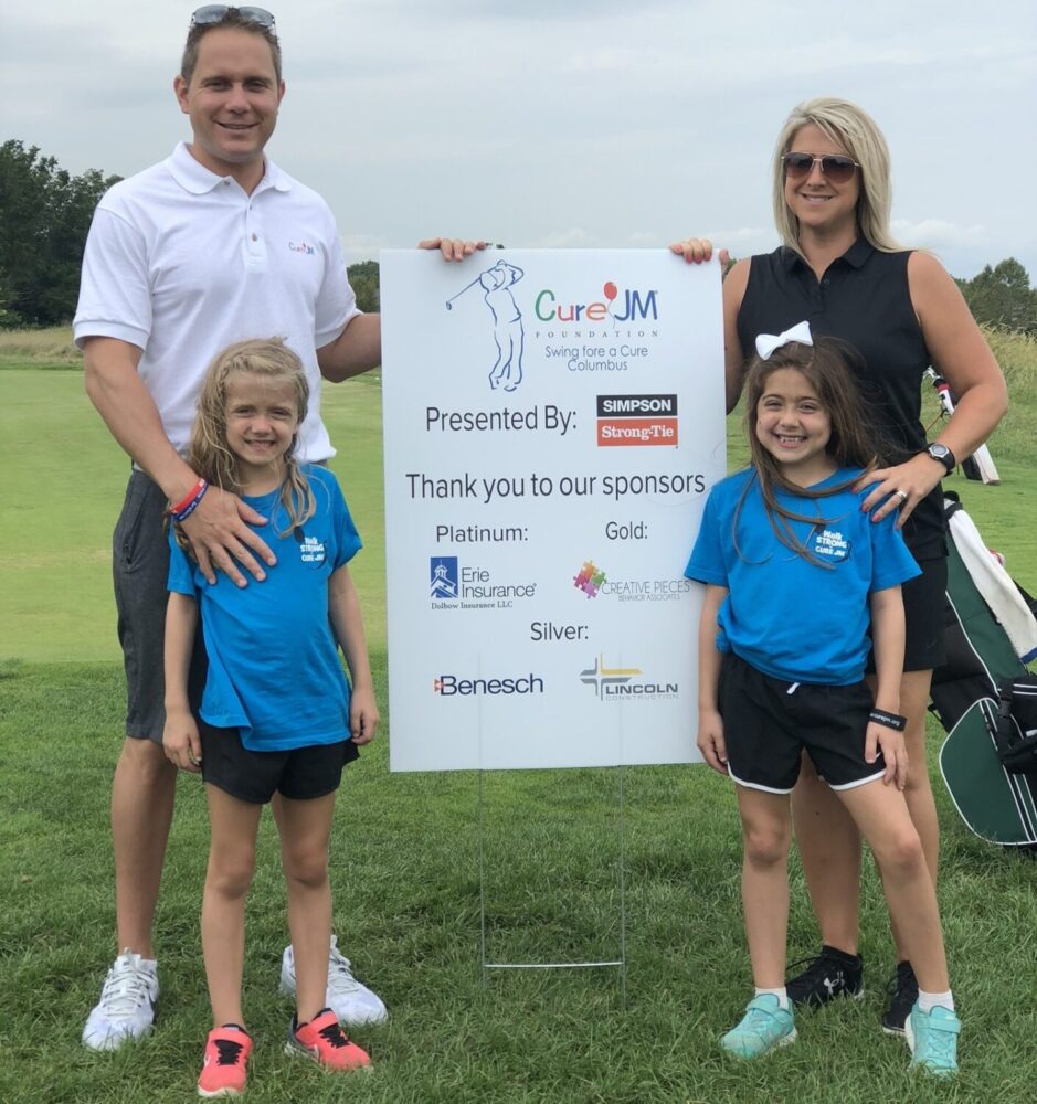 Family stands by event sign