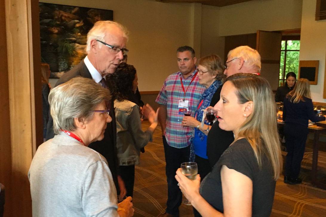 Group of people chat at a Cure JM gathering.