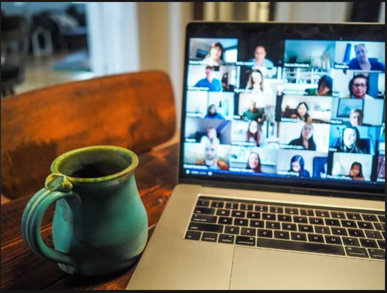 Photo of a zoom meeting with coffee cup and laptop