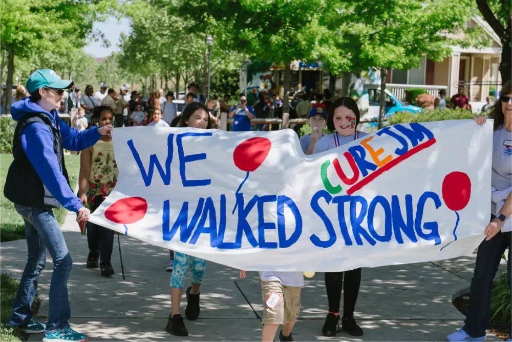 We Walked Strong Cure JM painted sign and families