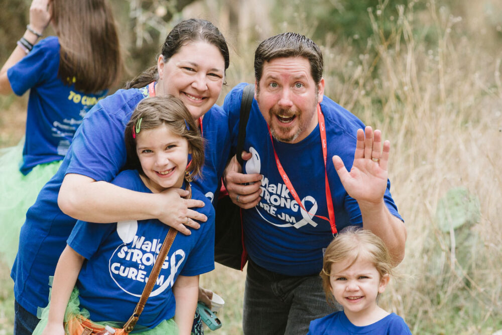 A family smiling and waving.